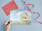 Greeting card with a yellow cat in a window, red envelope, and ribbon on a blue background